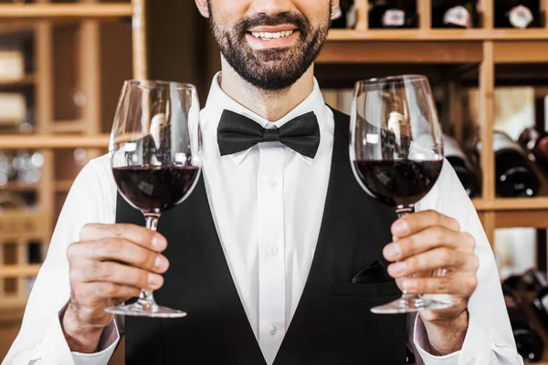 Tiro Recortado Sorrindo Jovem Sommelier Segurando Dois Copos Vinho Tinto — Fotografia de Stock