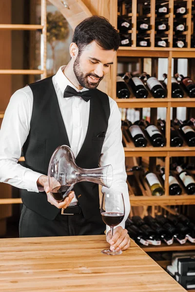 英俊的年轻侍酒师在葡萄酒店里浇瓶酒 — 图库照片