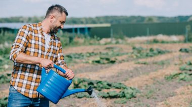 çiftçi sulama olabilir tutarak ve alanında çalışan kareli gömlekli 
