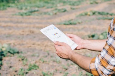 google web sitesi alan üzerinde dururken ile dijital tablet kullanarak çiftçinin kırpılmış atış  