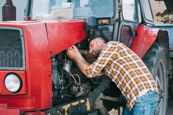 Yakışıklı Bir Orta Yaşlı Çiftçi Kareli Gömlekli Traktör Tamiri — Stok fotoğraf