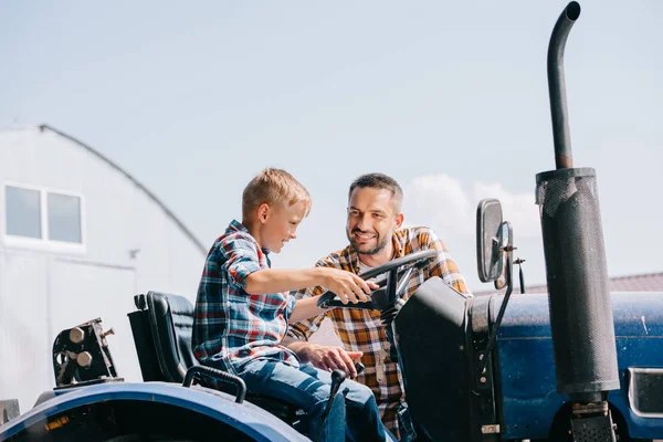 Glücklicher Vater Schaut Lächelnden Sohn Traktor Auf Bauernhof — Stockfoto