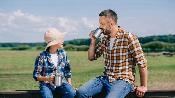 Happy Father Son Sitting Fence Drinking Metal Cups Farm — Stock Photo, Image