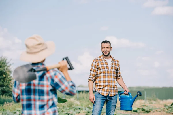 Selective Focus Boy Shovel Looking Smiling Father Watering Can Field — Stock Photo, Image