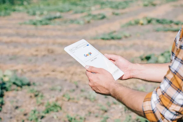 フィールドに立っている間 Google のウェブサイトでデジタル タブレットを使用して農家のクロップ撮影 — ストック写真