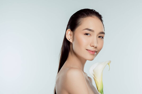 attractive asian girl with calla flower, isolated on grey
