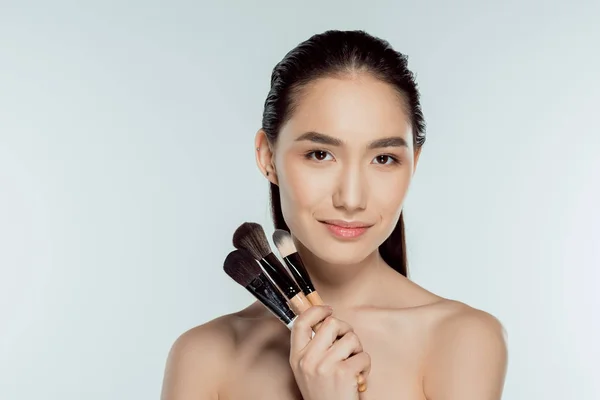 Vacker Asiatisk Tjej Håller Makeup Borstar Isolerad Grå — Stockfoto