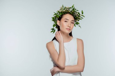 beautiful asian girl posing in floral wreath, isolated on grey clipart