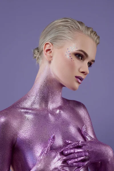 Chica Atractiva Pintada Con Brillo Ultravioleta Aislado Púrpura — Foto de stock gratis