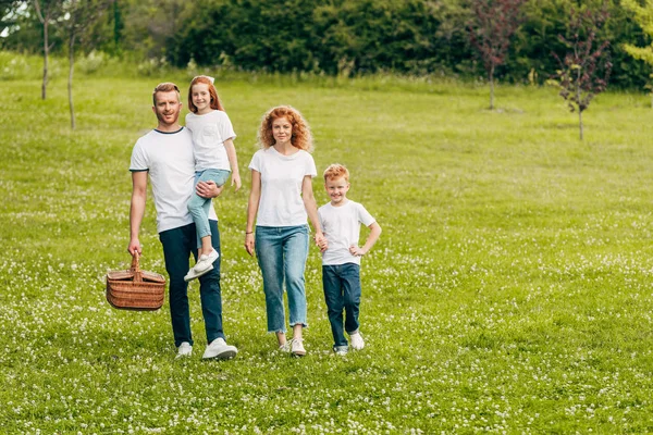 Glückliche Familie Lächelt Beim Spaziergang Mit Picknickkorb Park Die Kamera — Stockfoto