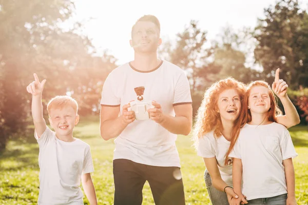 stock image happy family with two kids playing with drone in park