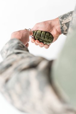 cropped shot of soldier holding grenade in hands on light backdrop clipart
