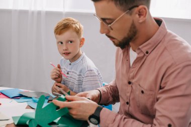 Kızıl saçlı okul öncesi öğretmen kesme gazetede sınıfta makas ile seyir