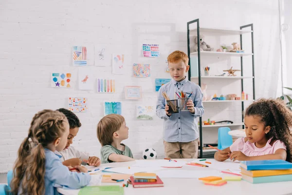 Niños Interracial Sentados Mesa Con Papeles Pinturas Para Dibujar Aula —  Fotos de Stock