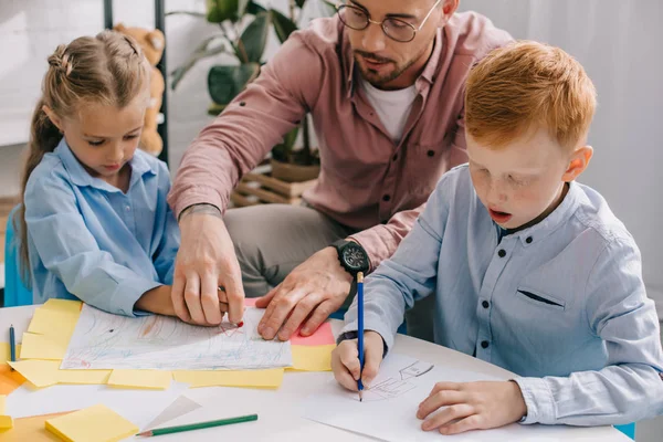 Profesor Anteojos Ayudando Los Niños Edad Preescolar Con Dibujo Mesa — Foto de Stock