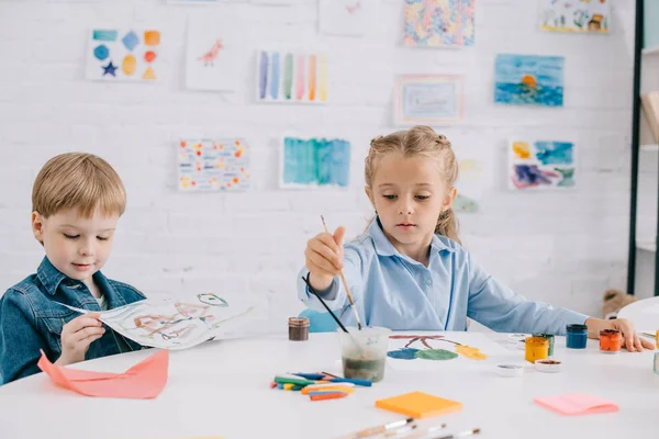 Εστιασμένη Preschoolers Αντλώντας Εικόνες Χρώματα Και Πινέλα Στο Τραπέζι Στην — Φωτογραφία Αρχείου