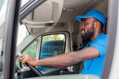side view of african american delivery man driving van  clipart