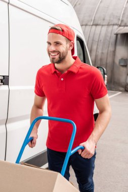 teslimatçı karton kutu üzerinde teslim cart ile gülümseyen