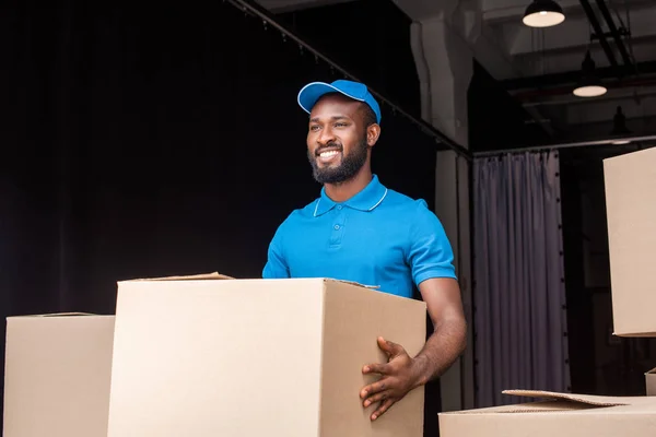 Sorridente Africano Americano Entrega Homem Segurando Caixa Perto Armazenamento — Fotografia de Stock