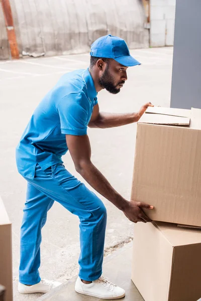 Side View African American Delivery Man Putting Boxes Pile — Stock Photo, Image