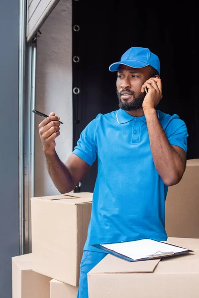 African American Delivery Man Talking Smartphone Looking Away — Stok Foto