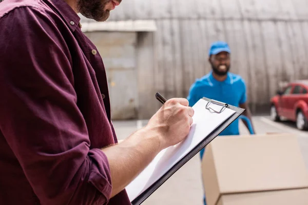 Imagen Recortada Del Cliente Escribiendo Algo Portapapeles Sobre Entrega — Foto de Stock