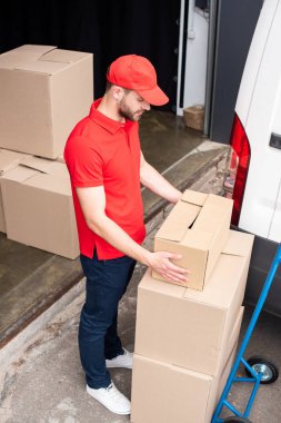 van dan karton kutular boşaltma genç teslimatçı yüksek açılı görünüş