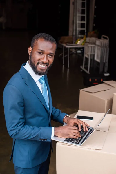 Vista Lateral Sorridente Empresário Afro Americano Com Laptop Caixa Papelão — Fotografia de Stock