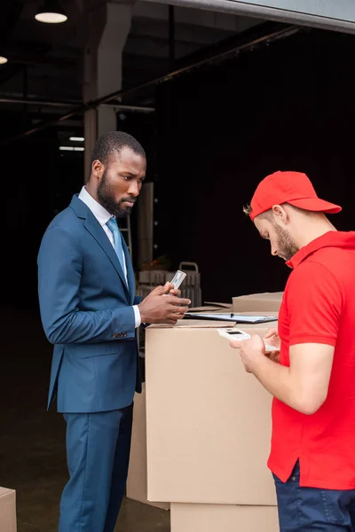 Cliente Afroamericano Con Dinero Repartidor Caucásico Con Calculadora —  Fotos de Stock