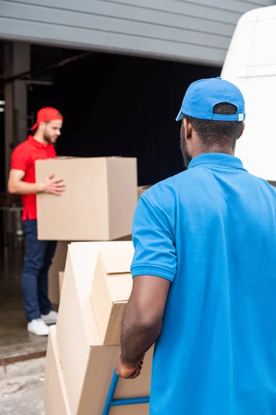 Multiethnic Delivery Men Red Blue Uniform Cardboard Boxes — Stock Photo, Image