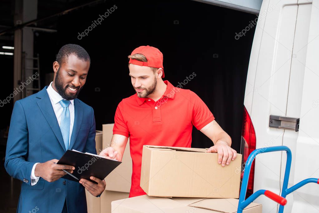 portrait of multicultural businessman and delivery man discussing order