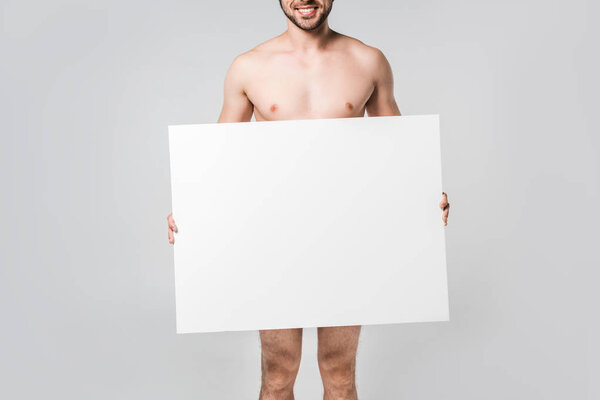 partial view of smiling naked man holding blank banner isolated on grey