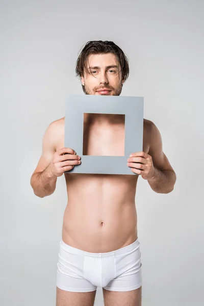 Retrato Hombre Joven Ropa Interior Sosteniendo Figura Papel Cuadrado Aislado — Foto de stock gratis