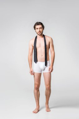 gri zemin üzerine siyah kravat ile beyaz iç çamaşırı yakışıklı adam