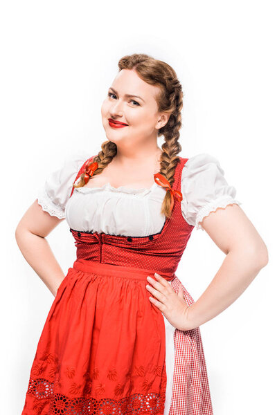 attractive oktoberfest waitress in traditional bavarian dress standing akimbo isolated on white background