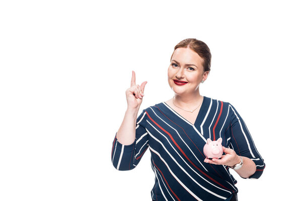 smiling businesswoman with pink piggy bank doing idea gesture isolated on white background 