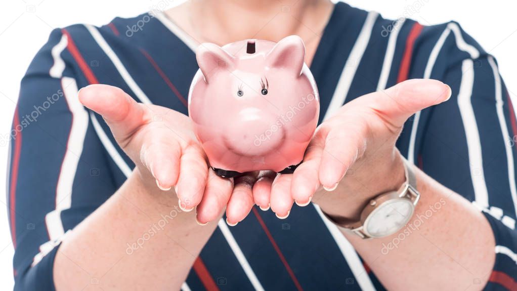 partial view of female accountant showing pink piggy bank isolated on white background 
