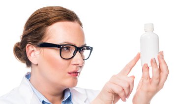 ciddi kadın doktor gözlük hap şişe beyaz arka plan üzerinde izole parmak tarafından işaret içinde 