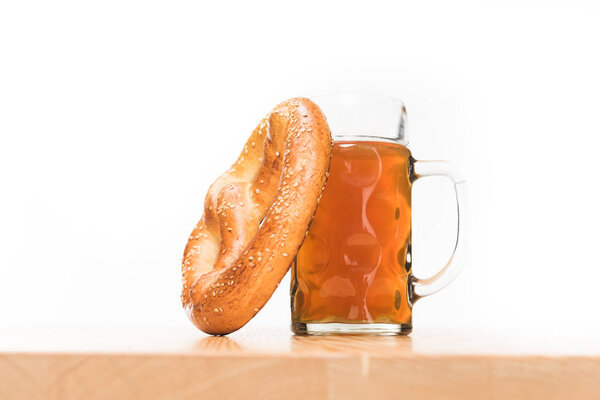 selective focus of pretzel and beer on wooden table on white background 