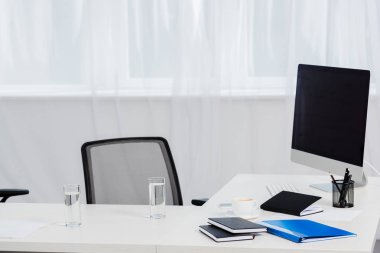yakın çekim modern ofis masası bardak su ve bilgisayar ile vurdu