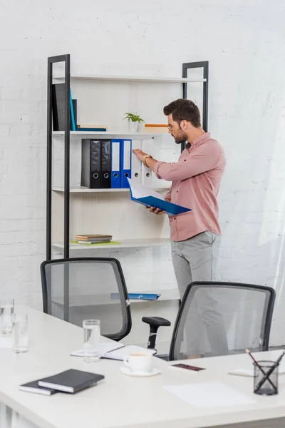 Pohledný Mladý Podnikatel Pořizování Složku Bookshelf Moderní Kanceláři — Stock fotografie