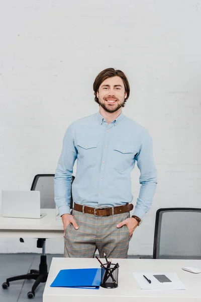 Gutaussehender Junger Geschäftsmann Blickt Modernem Büro Mit Den Händen Den — kostenloses Stockfoto