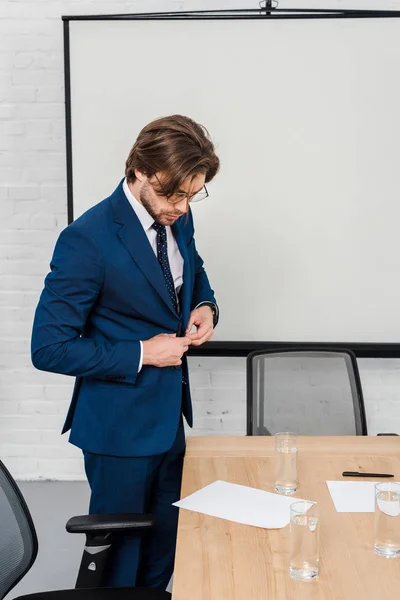 Attractive Young Businessman Reading Documents Buttoning Jacket Modern Office — Free Stock Photo