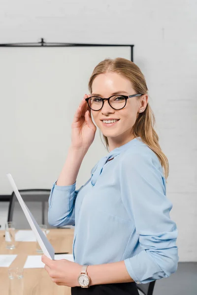 Giovane Donna Affari Sorridente Con Documenti Guardando Macchina Fotografica — Foto stock gratuita