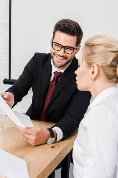 happy business partners discussing papers at modern office