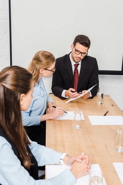 team of business people discussing documents at conference hall