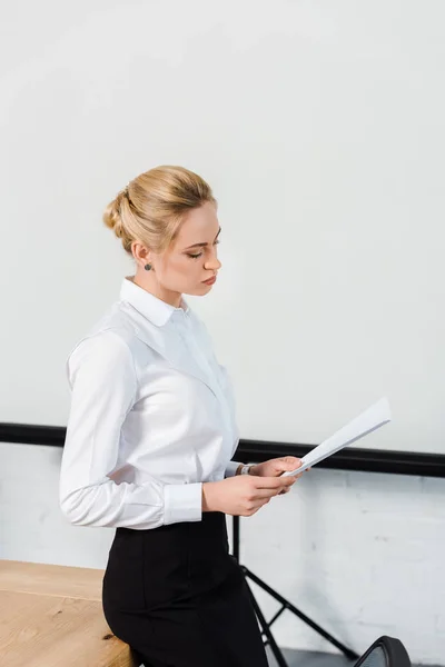 Focused Young Businesswoman Reading Documents Front Blank Presentation Board — Free Stock Photo