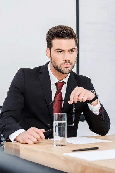 Nachdenklicher Junger Geschäftsmann Sitzt Modernem Büro Und Schaut Weg — Stockfoto