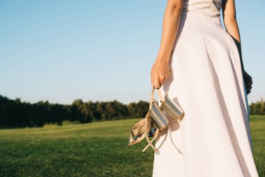 Ayakkabı tutarak ve Park'ta yürüyordunuz gelinlikle ihale genç gelinin kırpılmış atış