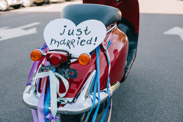back view of scooter with ribbons and romantic "just married" heart sign 